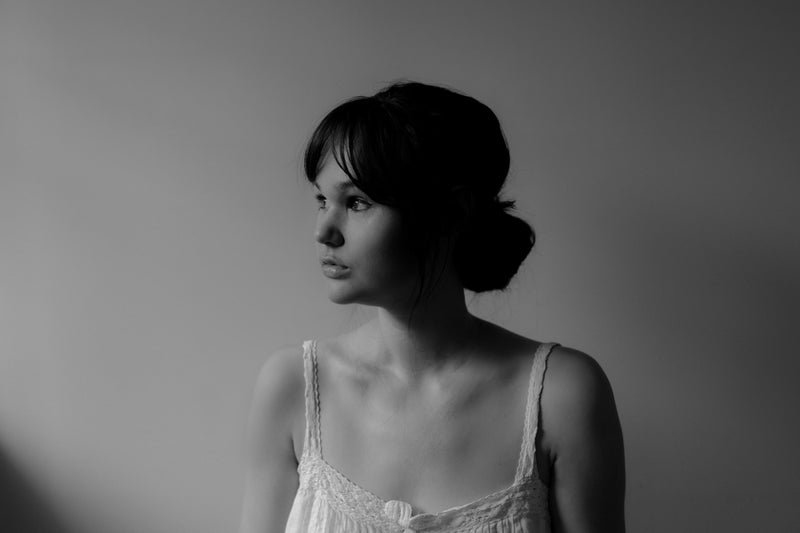 A black and white photo of Thalia Ho looking to the left and wearing a white tank