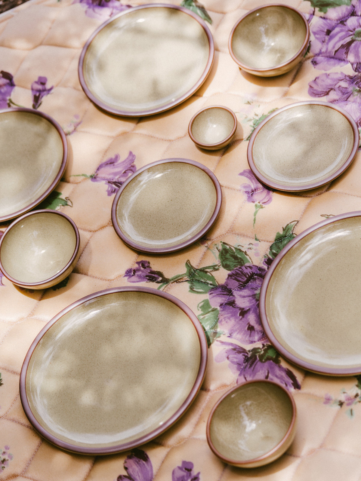 An assortment of plates and bowls on a blanket