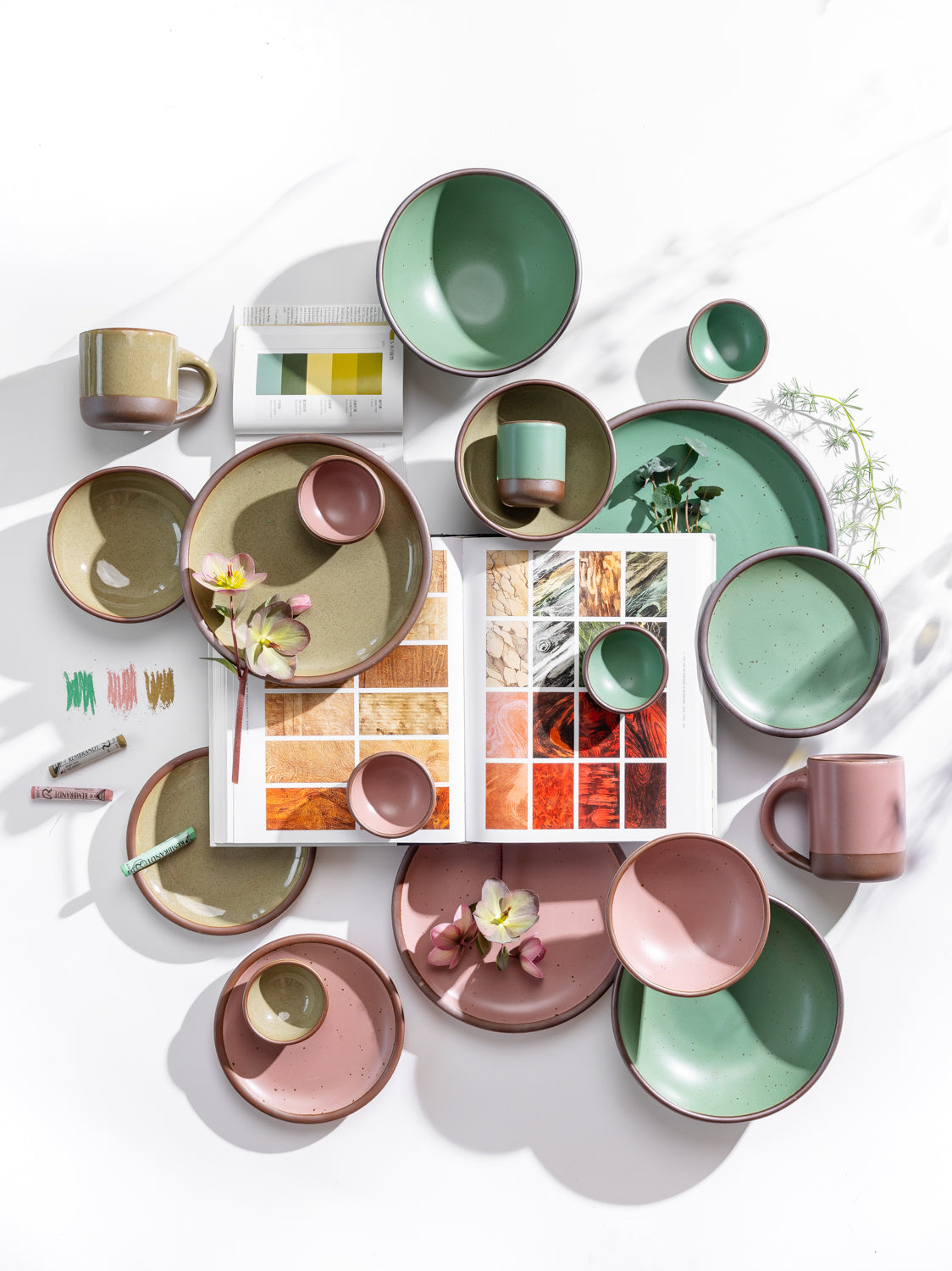 Pink and green pots on a white background topped with color swatches and florals.