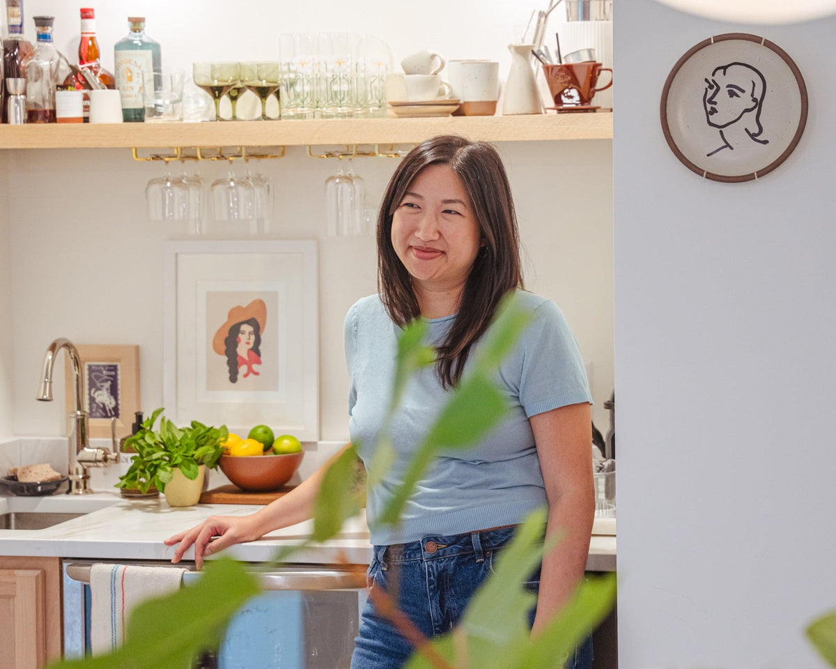 Ha standing and smiling in her kitchen
