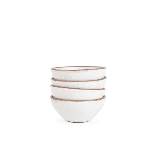 A stack of 4 small dessert sized rounded ceramic bowls in a cool white color featuring iron speckles and an unglazed rim