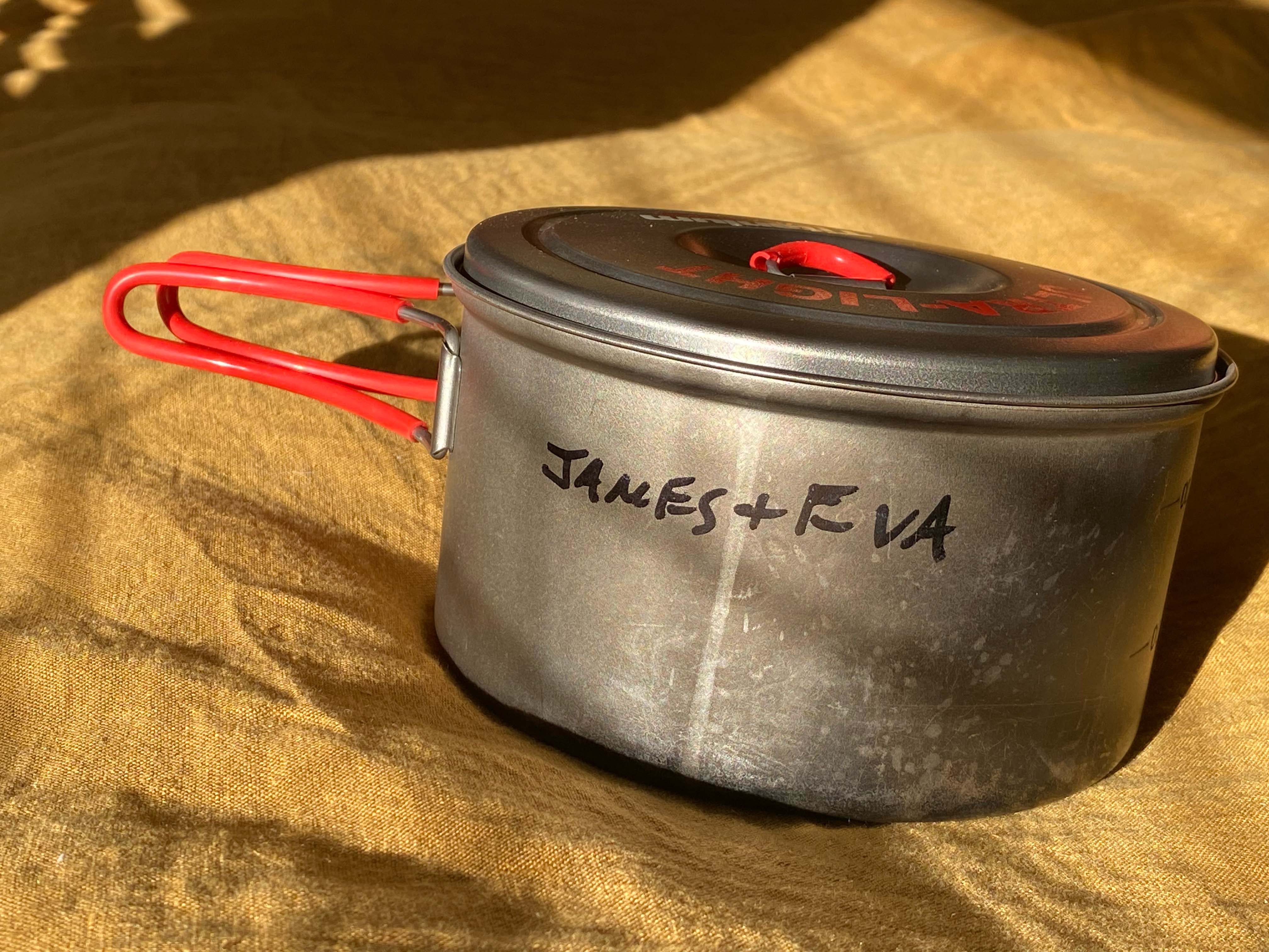 A metal pot with writing on it that reads