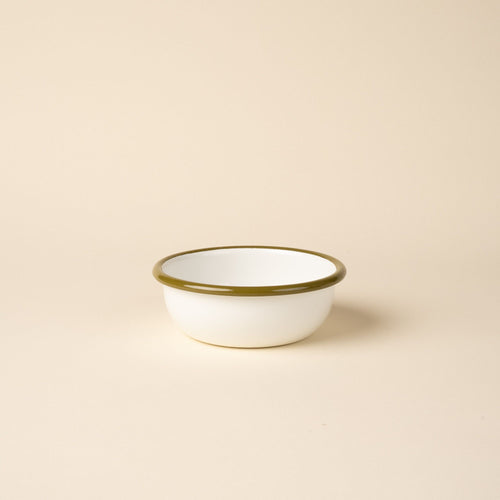 A small enamel bowl in white with an olive green rim.