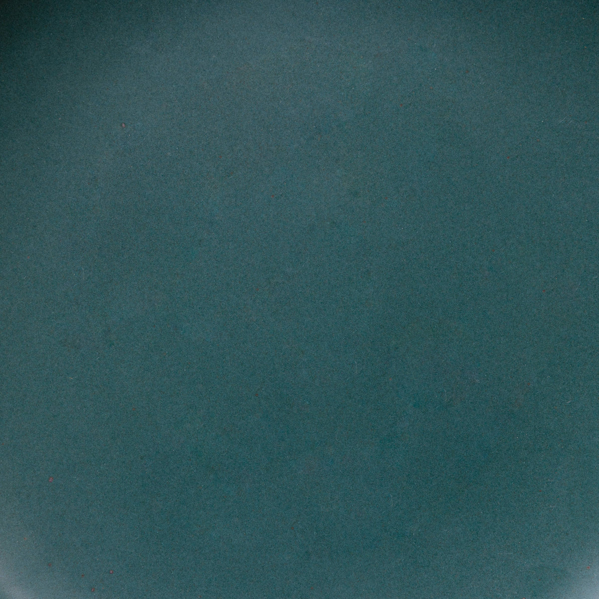 A closeup of a ceramic plate in a dark teal color