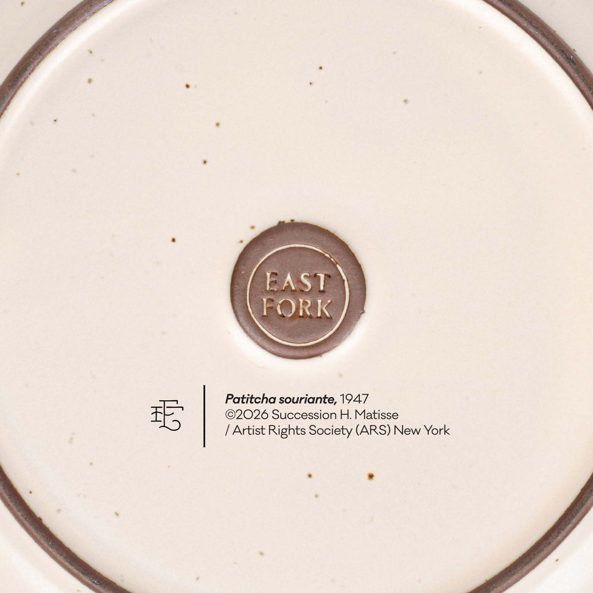 The back of a side plate with an East Fork stamp with a small decal of information about the artwork, Patitcha souriante, by Henri Matisse.