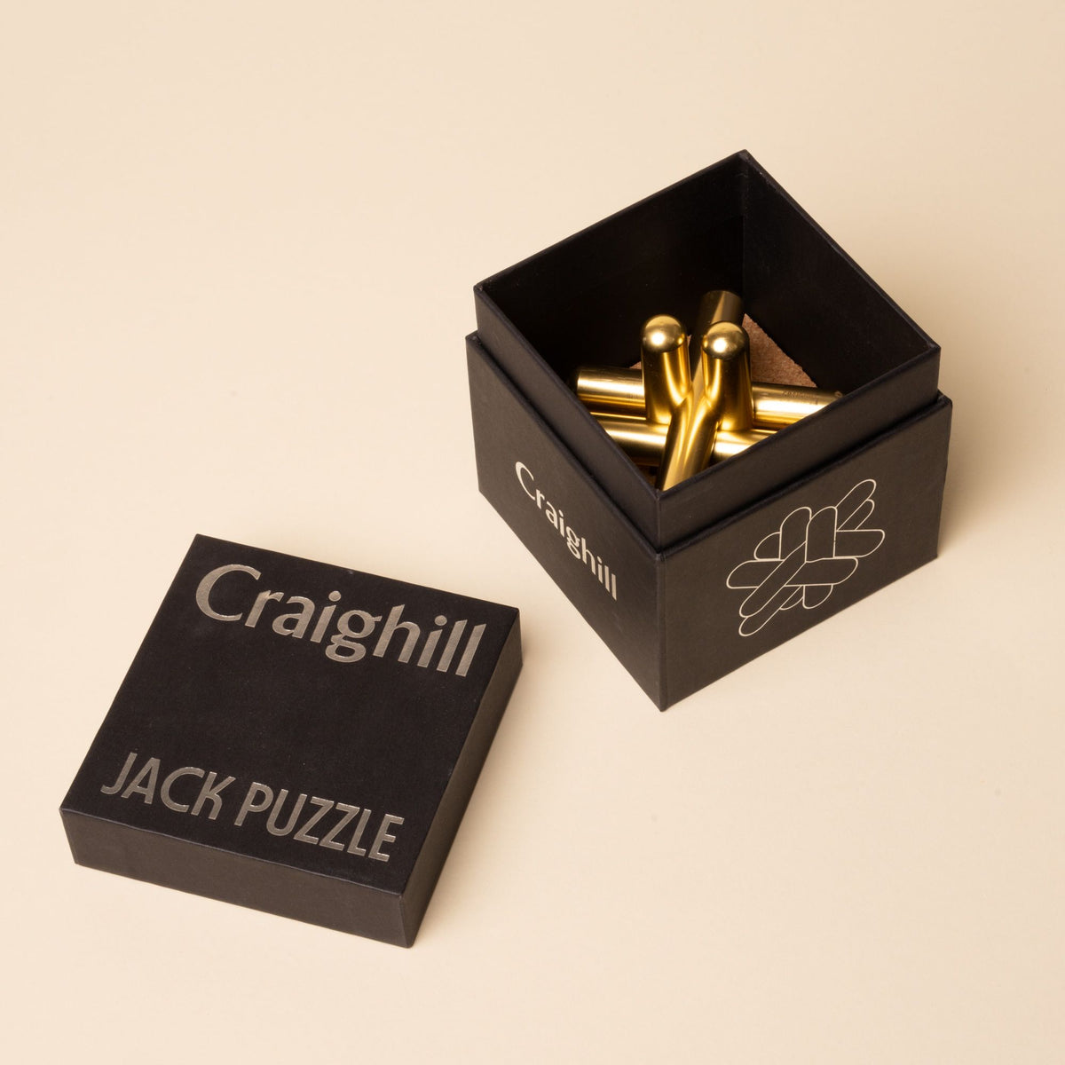 Open black Craighill box showing gold Jack Puzzle pieces inside, with the lid labeled “Jack Puzzle” beside it.