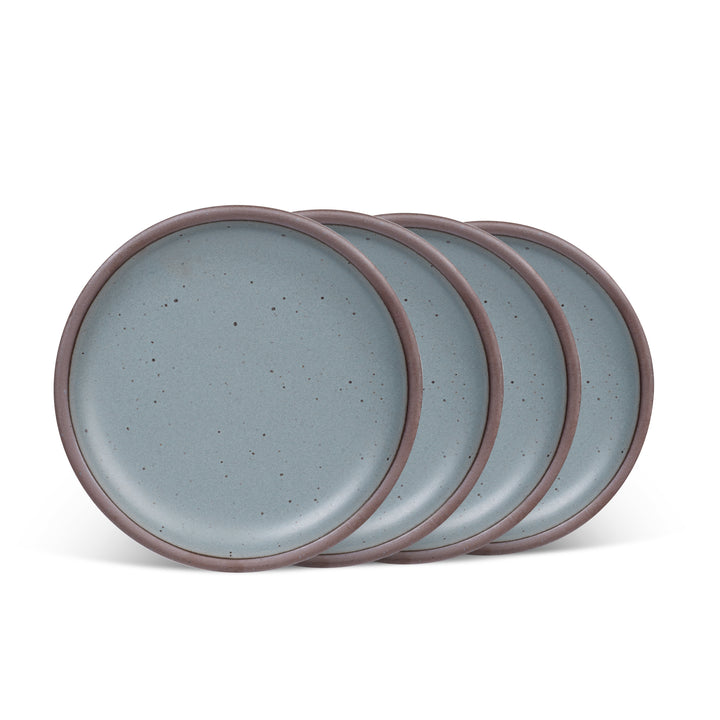 Set of four blue-grey ceramic side plates with unglazed rims on a white background