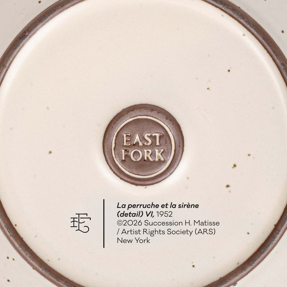 Close-up of the bottom of a ceramic plate or dish showing a circular brown logo reading EAST FORK in the center, with printed text below including 'La perruche et la sirène (detail) VI, 1952' and artist rights information.