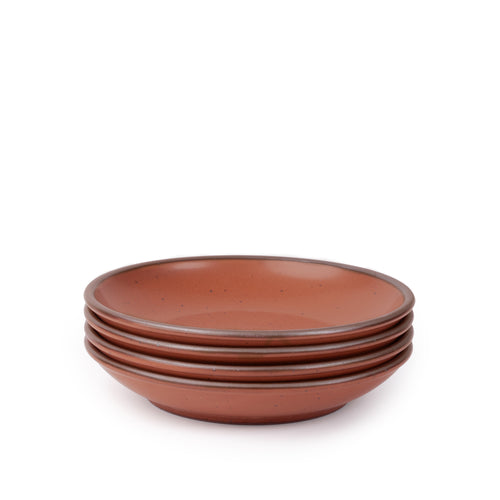 A stack of 4 medium ceramic plates with a curved bowl edge in a cool terracotta color featuring iron speckles and an unglazed rim.