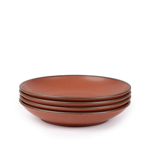 A stack of 4 large ceramic plates with a curved bowl edge in a cool terracotta color featuring iron speckles and an unglazed rim.