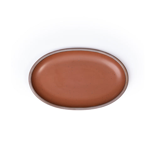 A medium oval ceramic platter in a cool terracotta color featuring iron speckles and an unglazed rim