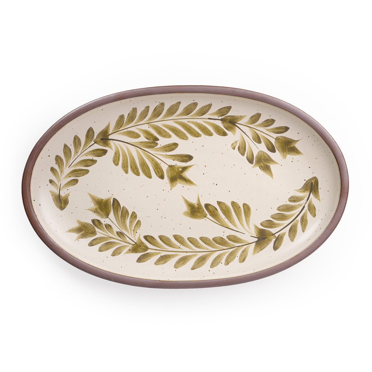 A large oval ceramic platter in a warm, tan-toned, off-white color featuring iron speckles and an unglazed rim, with handpainted greenery in an olive green color.