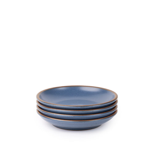 A stack of 4 small ceramic plates with a curved bowl edge in a blue color featuring iron speckles and an unglazed rim.