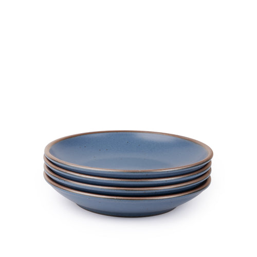 A stack of 4 medium ceramic plates with a curved bowl edge in a blue color featuring iron speckles and an unglazed rim.