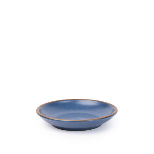 A small ceramic plate with a curved bowl edge in a toned-down navy color featuring iron speckles and an unglazed rim.
