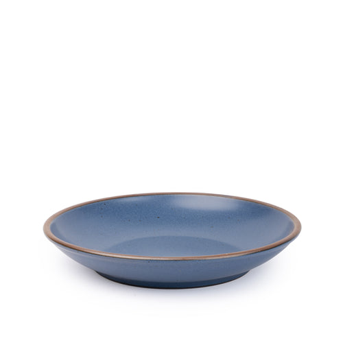 A large ceramic plate with a curved bowl edge in a toned-down navy color featuring iron speckles and an unglazed rim.