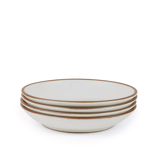 A stack of 4 large ceramic plates with a curved bowl edge in a cool white color featuring iron speckles and an unglazed rim.