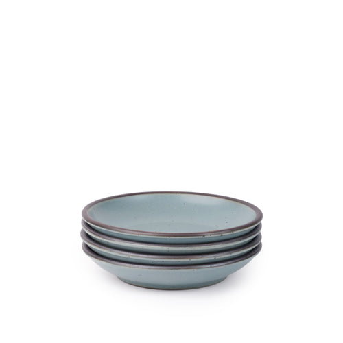 A stack of 4 small ceramic plates with a curved bowl edge in a blue-grey color featuring iron speckles and an unglazed rim.