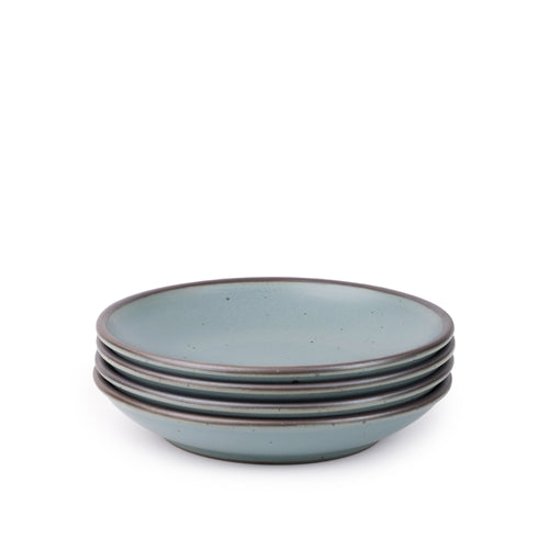 A stack of 4 medium ceramic plates with a curved bowl edge in a blue-grey color featuring iron speckles and an unglazed rim.
