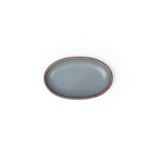 A small oval ceramic platter in a blue-grey color featuring iron speckles and an unglazed rim