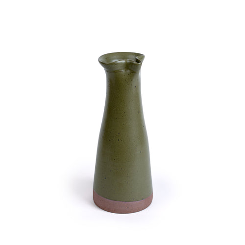 Tall ceramic carafe in an olive green color with iron speckles and an unglazed base.