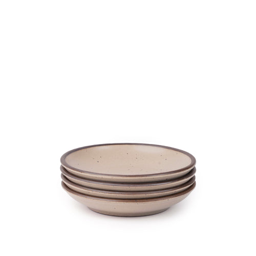 A stack of 4 small ceramic plates with a curved bowl edge in a pale warm brown color featuring iron speckles and an unglazed rim.