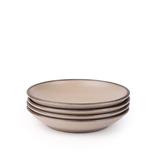 A stack of 4 medium ceramic plates with a curved bowl edge in a pale warm brown color featuring iron speckles and an unglazed rim.