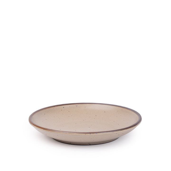 A medium ceramic plate with a curved bowl edge in a warm pale brown color featuring iron speckles and an unglazed rim.