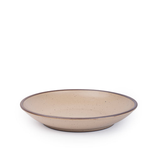A large ceramic plate with a curved bowl edge in a warm pale brown color featuring iron speckles and an unglazed rim.