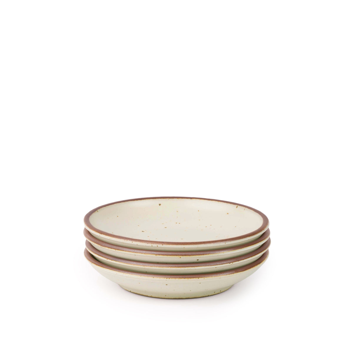 A stack of 4 small ceramic plates with a curved bowl edge in a warm off-white color featuring iron speckles and an unglazed rim.