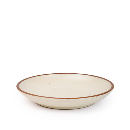 A large ceramic plate with a curved bowl edge in a warm, tan-toned, off-white color featuring iron speckles and an unglazed rim.
