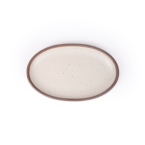 A medium oval ceramic platter in a warm off-white color featuring iron speckles and an unglazed rim