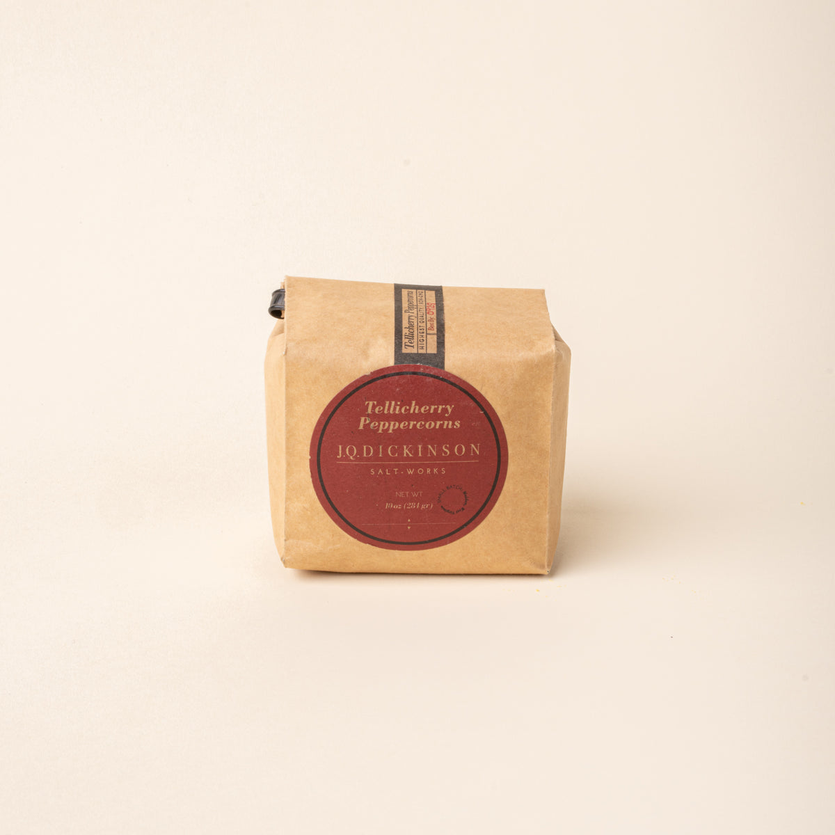 Bag of J.Q. Dickinson Tellicherry Peppercorns on a plain white background.