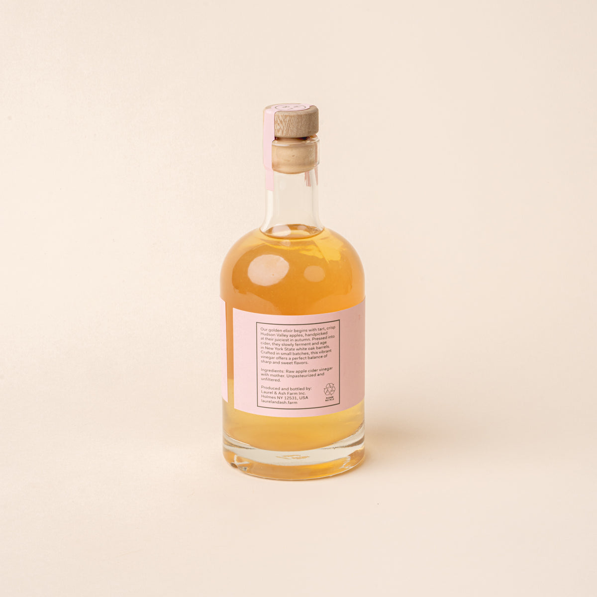 Back of Laurel & Ash Farm barrel-aged apple cider vinegar bottle with product information label on a plain white background.