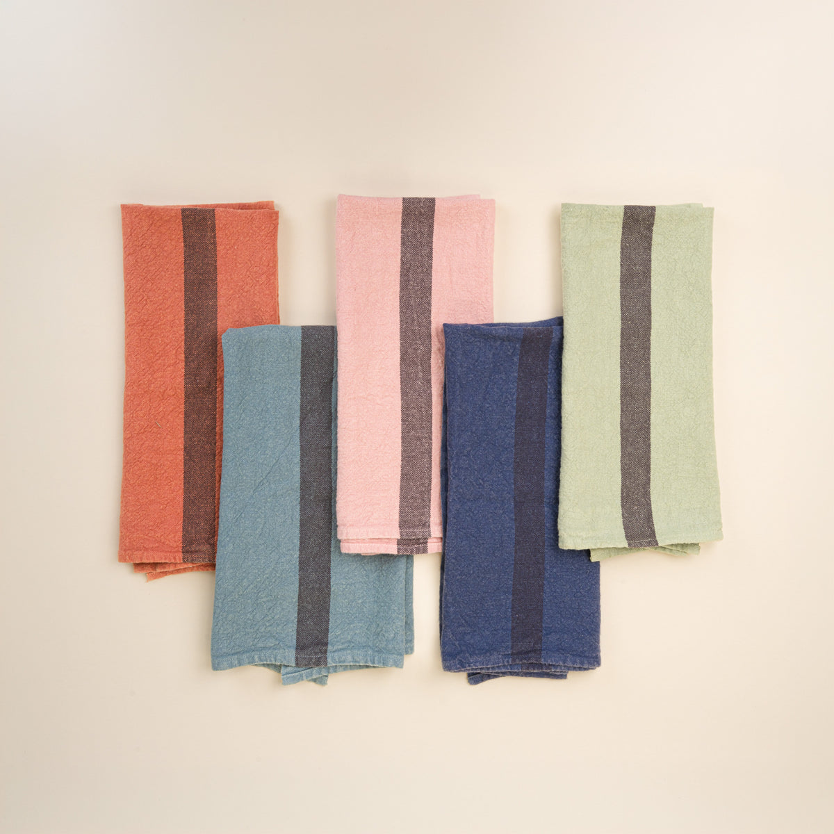 5 folded linen towels in a variety of colors with a grey stripe in the middle of each