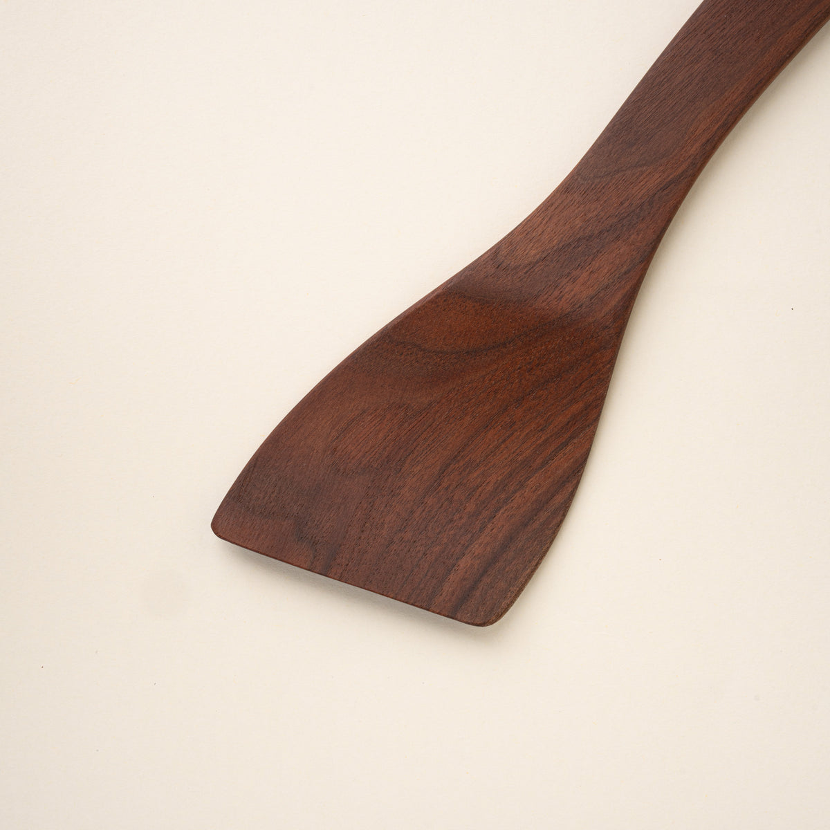 Closeup of a wooden spatula on a beige background