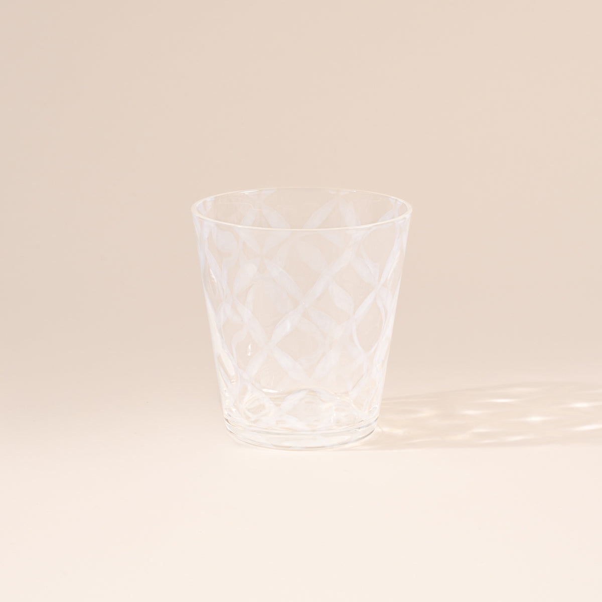 A short clear glass with a delicate grid pattern