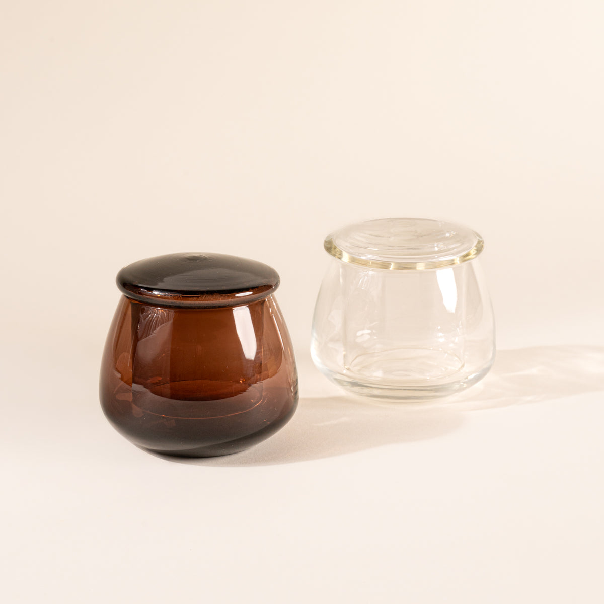 Walnut and clear glass butter keepers on white background