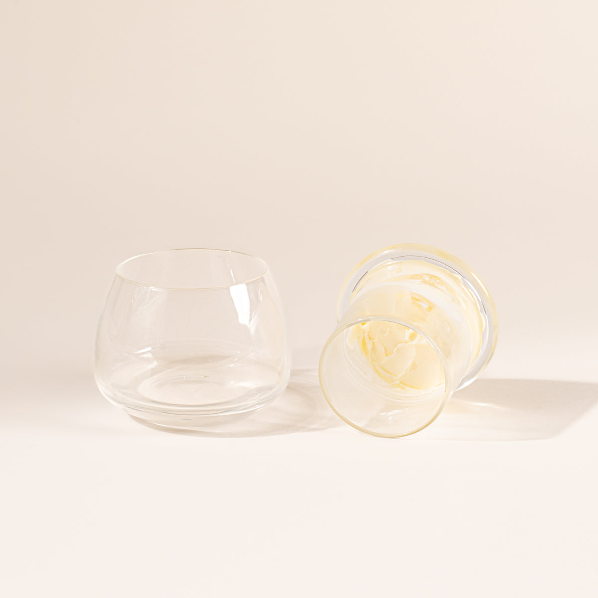The top of the clear butter keeper filled with butter, resting to the right of the rounded base.