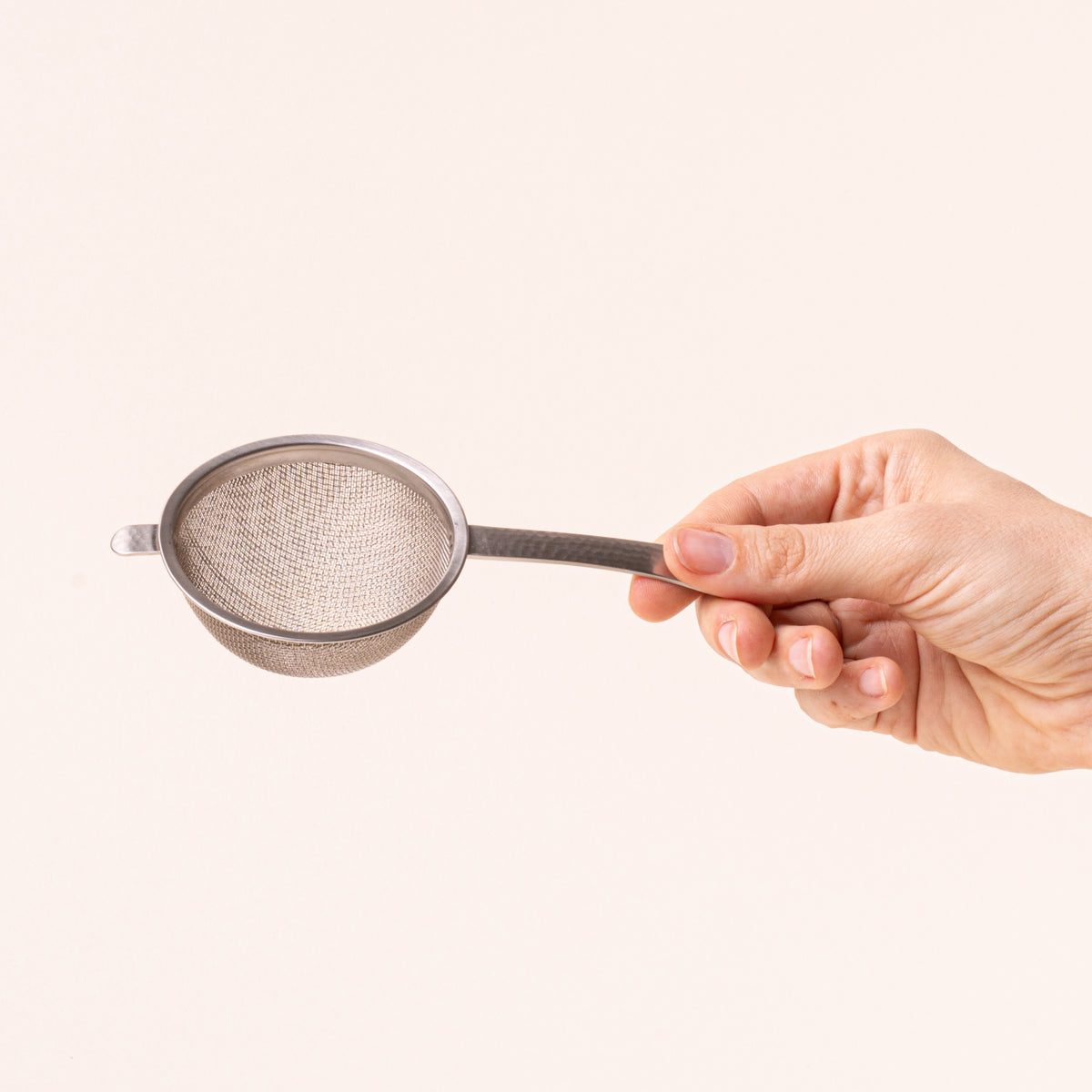 Hand holding handle of Stainless steel half dome strainer with steel handle