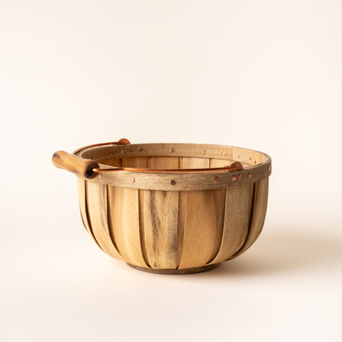 Round wooden gathering small basket with copper handle and rivet details, shown against a light background.