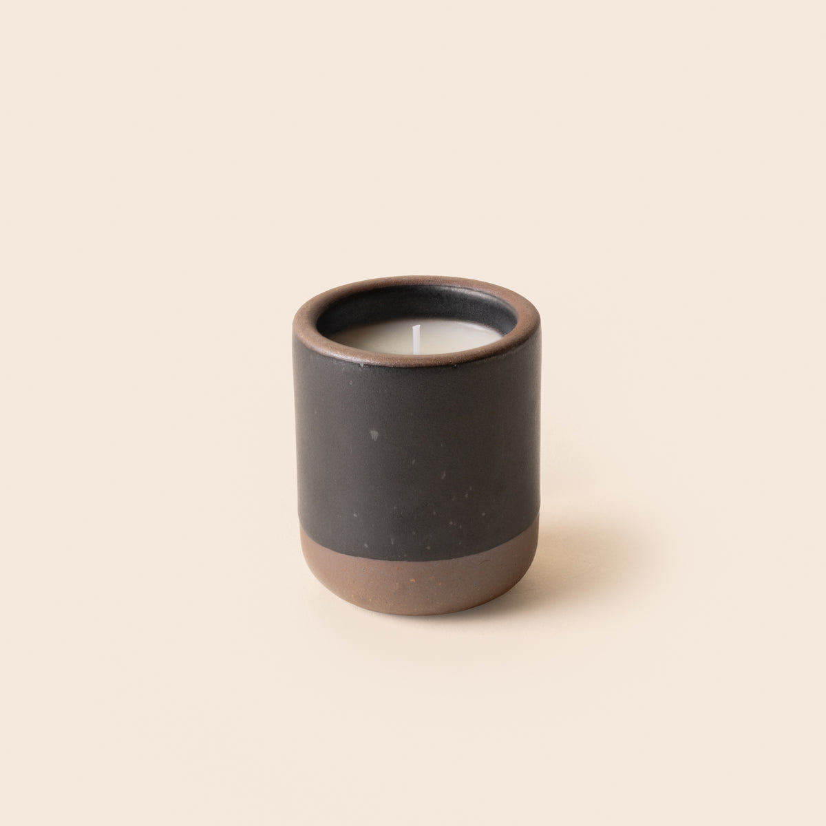 Small ceramic vessel in a black color with candle inside.
