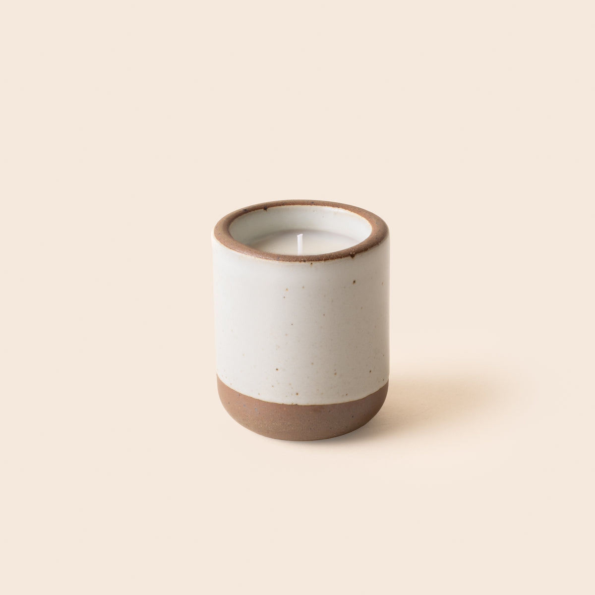 Small ceramic vessel in a cool white color with candle inside.