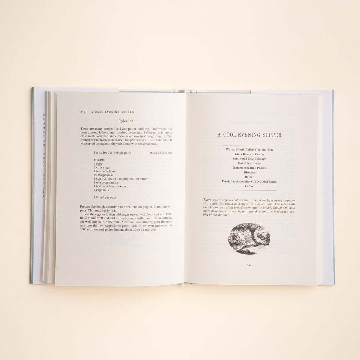 An open book laid flat on a light beige background, showing two printed recipe pages with text and a small black-and-white illustration.