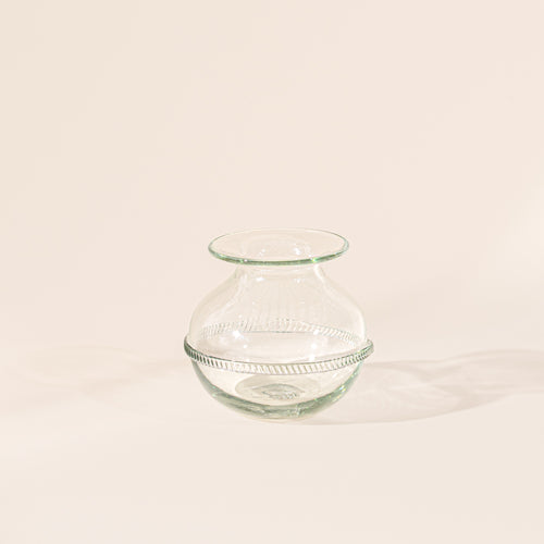 Small clear glass vase with a rounded body, flared rim, and decorative band around the center, displayed on a neutral background.