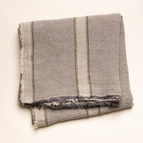 Soft gray linen tablecloth with cream and olive woven stripes and fringed edges, neatly folded on a clean neutral background.