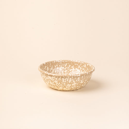 A medium enamel bowl in neutral tan color with off-white splatter pattern.