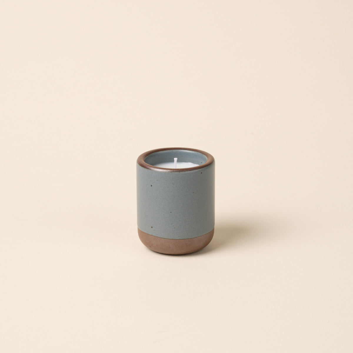 Small ceramic vessel in a blue-grey color with candle inside.