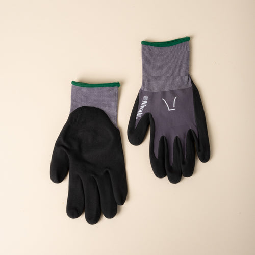Pair of gray and black gardening gloves with green trim, shown palms and backs on a neutral background.