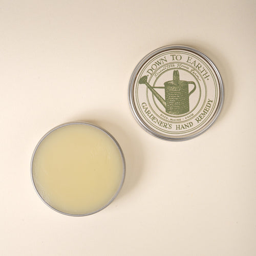 Balm container labeled 'Down to Earth Gardener's Hand Remedy' on a beige background